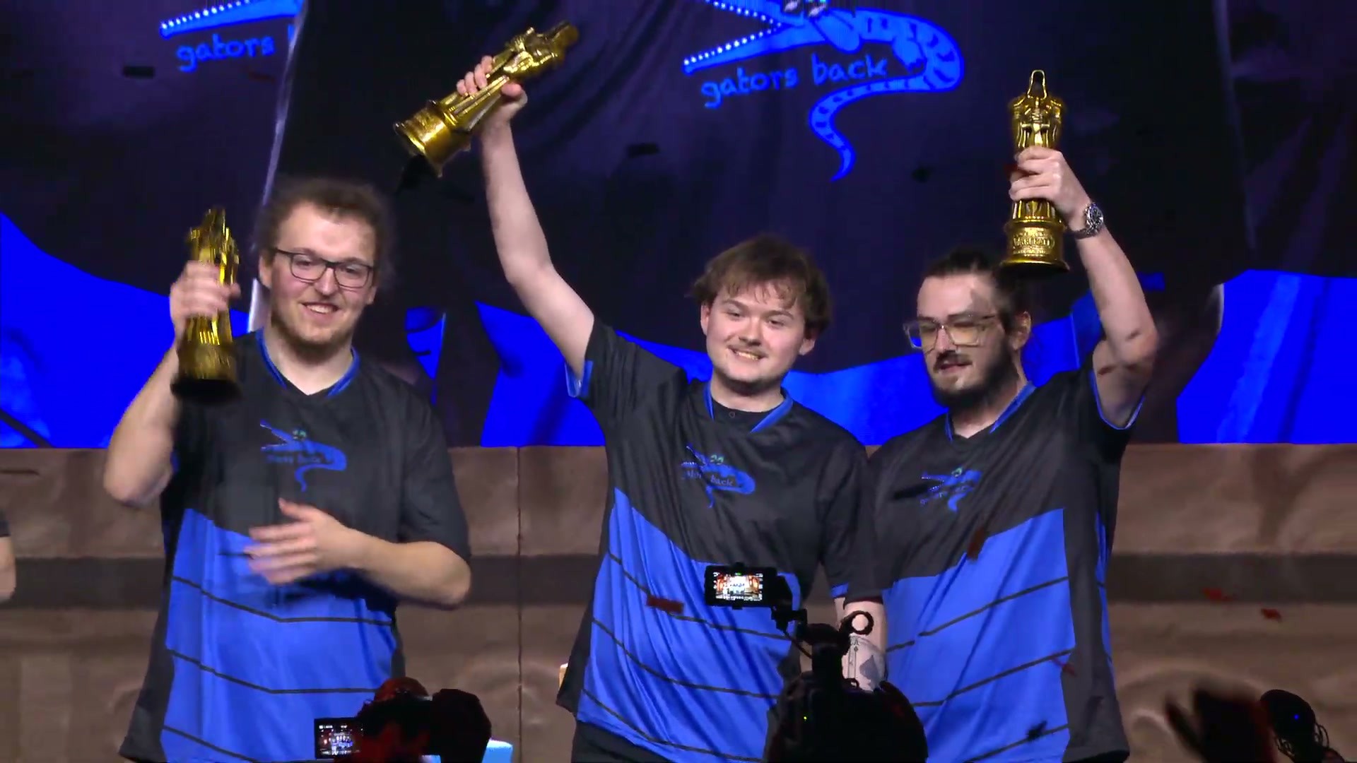 Gators Back players lift their trophies on stage after winning the Arena World Championship at BlizzCon 2026