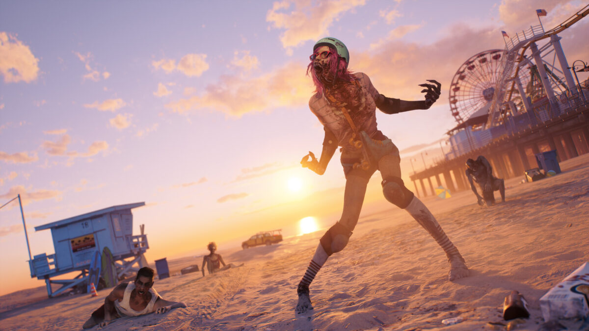 A pink-haired zombie in a helmet lurching across a sunset beach in Dead Island 2, with a Ferris wheel on the pier behind